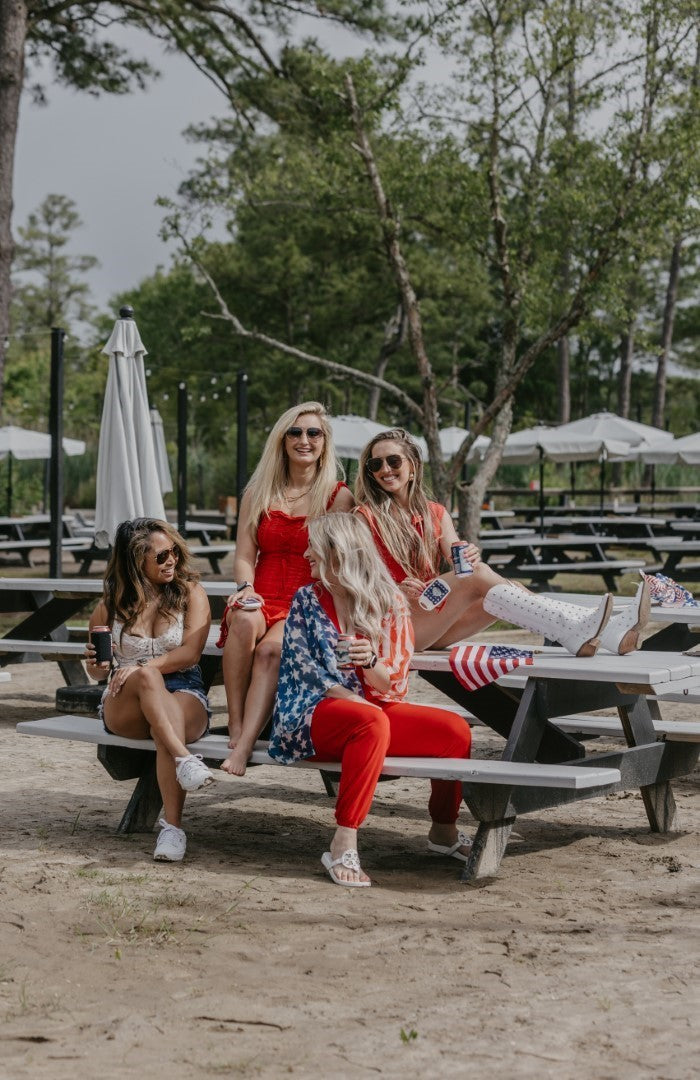 Four women sitting on a table outside happy with Draft Top Lifts 